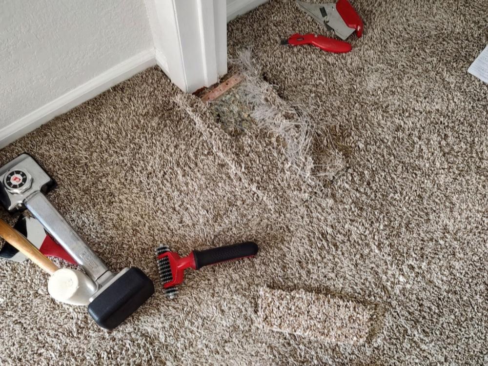 Carpet patch repair at a doorway with a knee kicker and carpet tools