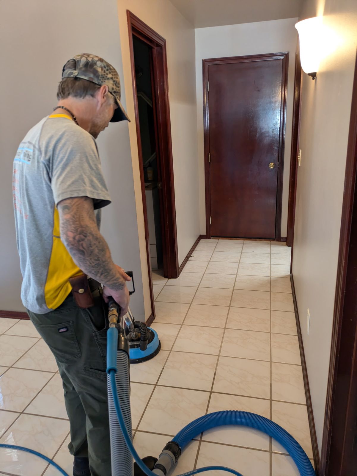 Raindrop Cleaning technician cleaning a tile floor with a spinner tool