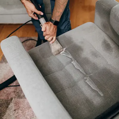 Upholstery tool leaving a clean stripe across a dirty gray chair